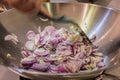 Stir-frying chopped onions, shallots and garlic in a wok.