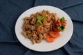 Stir shrimp macaroni on a white plate with carrots, tomatoes and salad