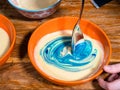 Stirring blue food coloring in bowl of dough Royalty Free Stock Photo