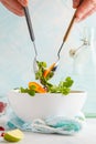 Stirring a bright persimmon salad. Healthy green vegetarian food