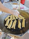 stirring Chinese fried dough in the hot oily cooking pan Royalty Free Stock Photo