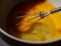 Stirring eggs for recipe with a whisk close up