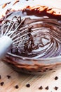 Stirring melted chocolate chips in bowl up-close on wood table Royalty Free Stock Photo