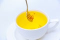 Stirring stamens in saffron tea on a white background. Royalty Free Stock Photo