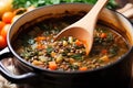 stirring vegetable lentil soup with a wooden spoon