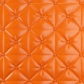 Stitched upholstery leather orange background with buttons