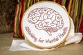 Stitching for mental health text with embroidered brain stitched on linen in embroidery hoop