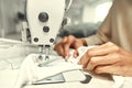 Stitching Up. Close up of seamstress hands. She is sitting and sewing. Dressmaker working on the sewing machine. Tailor