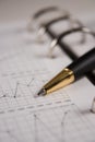 Stock chart with a pen Royalty Free Stock Photo