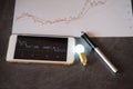 Stock chart on smartphone screen with blurred bulb light idea Royalty Free Stock Photo