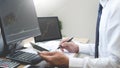 Stock exchange trader Analyzing Graphs chart or data On Multiple Screens in office