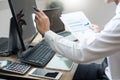 Stock exchange trader Analyzing Graphs chart or data On Multiple Screens in office