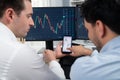 Stock exchange traders pointing lowest chart stage on dynamic graph. Sellable.