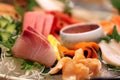 Stock image of a colorful platter of sashimi sushi with tuna and crab sticks in foreground and cucumber decorations Royalty Free Stock Photo