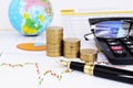 Stock invesment concept with fountain pen and coins stack and calculator Royalty Free Stock Photo