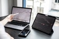 A stock investor holding a pen pointing to a laptop screen opens a stock chart program to read stock price charts. Royalty Free Stock Photo