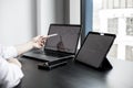 A stock investor holding a pen pointing to a laptop screen opens a stock chart program to read stock price charts. Royalty Free Stock Photo