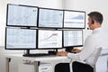 Stock Market Broker Looking At Graphs On Multiple Screens Royalty Free Stock Photo