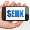 Stock market indexes concept: Hand Holding Smartphone with SEHK on display Royalty Free Stock Photo