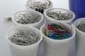 Stock of office pins in white plastick cups