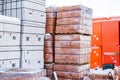 Stock pallets of red bricks wrapped in stretch film at wholesale outdoor market ot store. Construction site with prepared Royalty Free Stock Photo