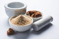 Stock Photo of Asafoetida powder / Hing or Heeng with cake and mortar