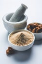 Stock Photo of Asafoetida powder / Hing or Heeng with cake and mortar