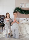 Eautiful little girl and boy are on the bed in the bedroom with Christmas decoration Royalty Free Stock Photo