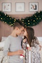 Eautiful little girl and boy are on the bed in the bedroom with Christmas decoration