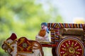 Stock photo of a beautiful traditional Indian wooden bull cart and statue of farmer sitting on bull cart, kept on grains on sunny