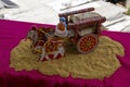 Stock photo of a beautiful traditional Indian wooden bull cart and statue of farmer sitting on bull cart, kept on grains on sunny