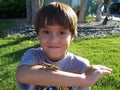 Stock Photo of Boy Playing with Grasshopper