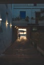 Cozy alleyway at sunset in Italy with illuminated lamps and parked scooter