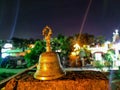 Stock photo of carved designer copper or bronze bell used for worshiping god kept on red color brick under bright light. Picture