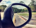 Stock photo features a rear view of a side car mirror reflecting a highway road Royalty Free Stock Photo