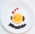 Food art. Little fish from fruit, creative idea for healthy breakfast on the white plate