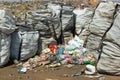 Stock photo of garbage collection bags and empty plastic bottles on waste disposal site