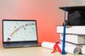 Stock photo of a graduation cap mortar board with books and diploma certificate isolated on wooden table against RGB color Royalty Free Stock Photo