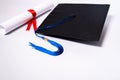 Stock photo of a graduation cap mortar board and diploma certificate isolated on white background with negative copy space to add Royalty Free Stock Photo