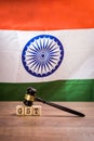 Stock photo of GST low in india. GST text written over wooden blocks with wooden gavel over it and indian national flag or tricol