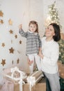 Little beautiful girl with mother near the festive christmas tree Royalty Free Stock Photo