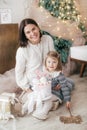 Little beautiful girl with mother near the festive christmas tree Royalty Free Stock Photo