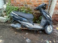 Stock photo old damaged black color suzuki access scooter, scooty or bike parked near the wall. Royalty Free Stock Photo