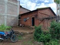 Stock photo of old style red brick house with traditional pyramid shape roof top in Indian village ,small shelter beside the house Royalty Free Stock Photo