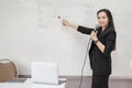 Stock photo portrait of a confident cheerful Asian woman teacher in a black business suit uniform with a digital tablet and laptop Royalty Free Stock Photo