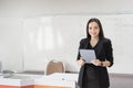 Stock photo portrait of a confident cheerful Asian woman teacher in a black business suit uniform with a digital tablet and laptop Royalty Free Stock Photo