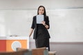 Stock photo portrait of a confident cheerful Asian woman teacher in a black business suit uniform with a digital tablet and laptop Royalty Free Stock Photo