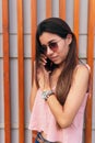 Stock photo of a portrait of a young Caucasian woman talking on a cell phone. She is wearing casual clothes and sunglasses Royalty Free Stock Photo