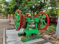 Stock photo of side view of green and red color sugarcane juice maker machine at road side of the Indian village street . Royalty Free Stock Photo