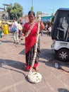 Stock photo of 30 to 40 age group Indian women wearing black and red color saree, selling fresh flower garland in market area.